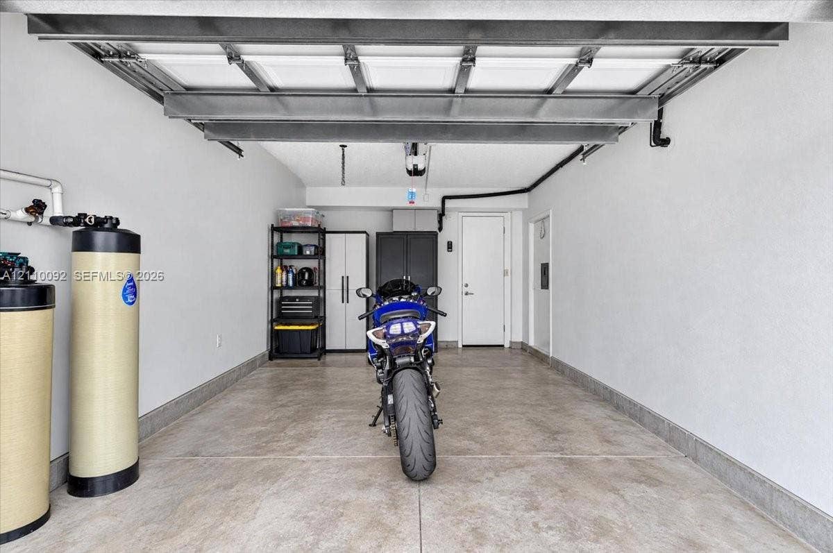 1403 SW 110th Way, Davie, FL 33324 Garage featuring concrete flooring, interior walls with a neutral finish, and a dedicated water filtration system