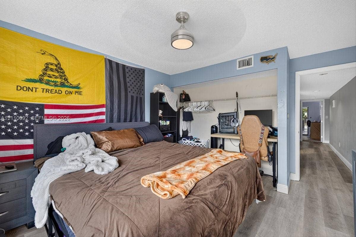 1403 SW 110th Way, Davie, FL 33324 Room featuring wood-finish flooring, a neutral paint palette, and a central brushed-metal ceiling fixture with integrated lighting