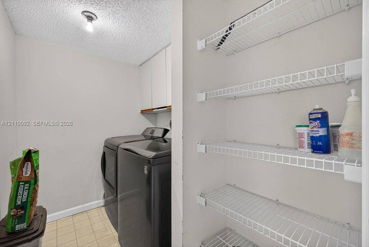 1403 SW 110th Way, Davie, FL 33324 Laundry area featuring white cabinetry, wire shelving, and tiled flooring