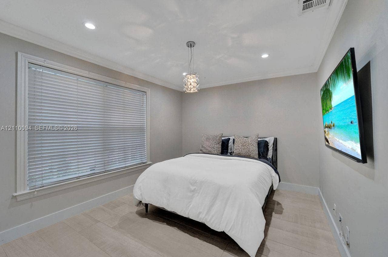 2064 Island Circle, Weston, FL 33326 Neutral interior featuring light-toned tile flooring, crown molding, recessed lighting, a modern crystal pendant light fixture, and horizontal window blinds