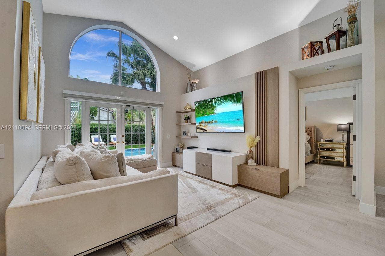 2064 Island Circle, Weston, FL 33326 Vaulted ceiling, arched window, wood-finish flooring, built-in cabinetry, and French doors