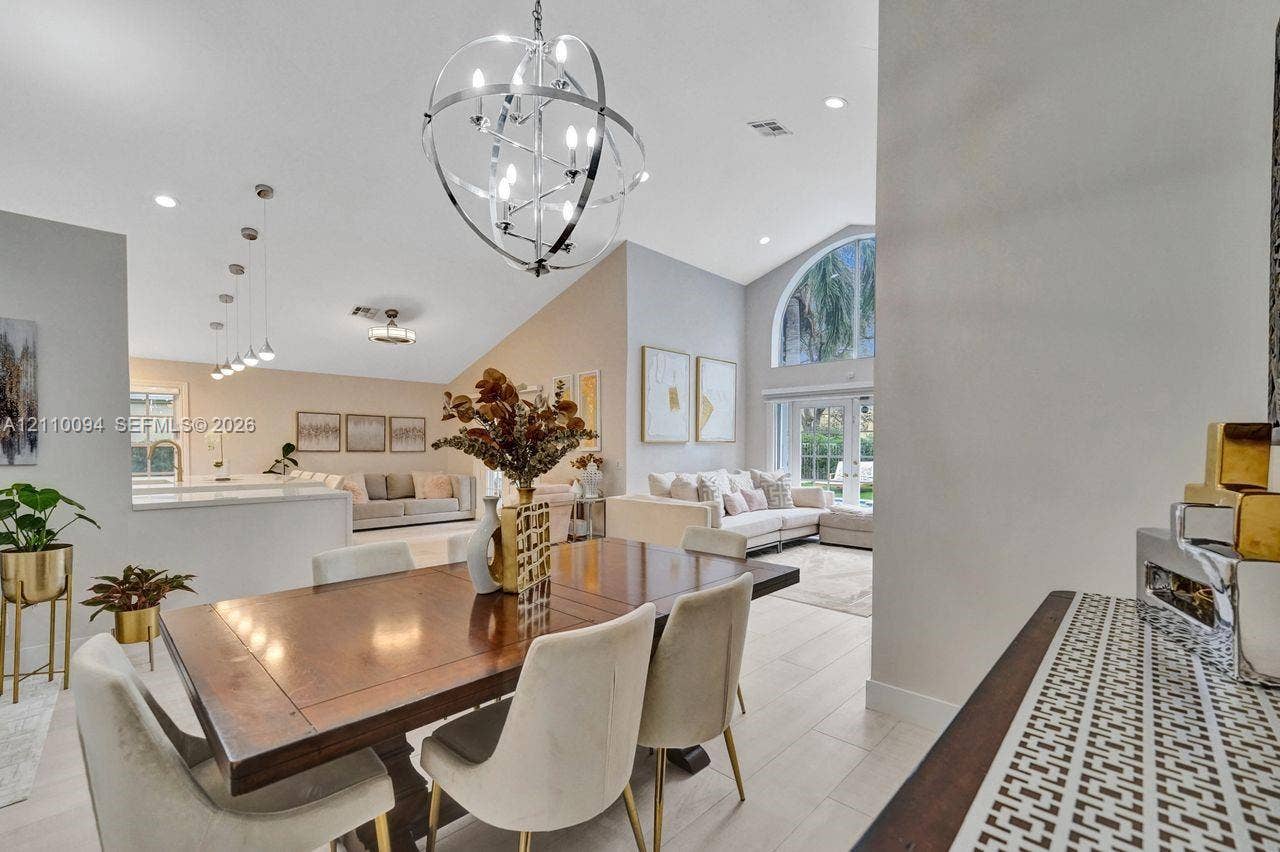 2064 Island Circle, Weston, FL 33326 Vaulted ceilings, large arched window, spherical metallic chandelier, recessed lighting, and tile flooring