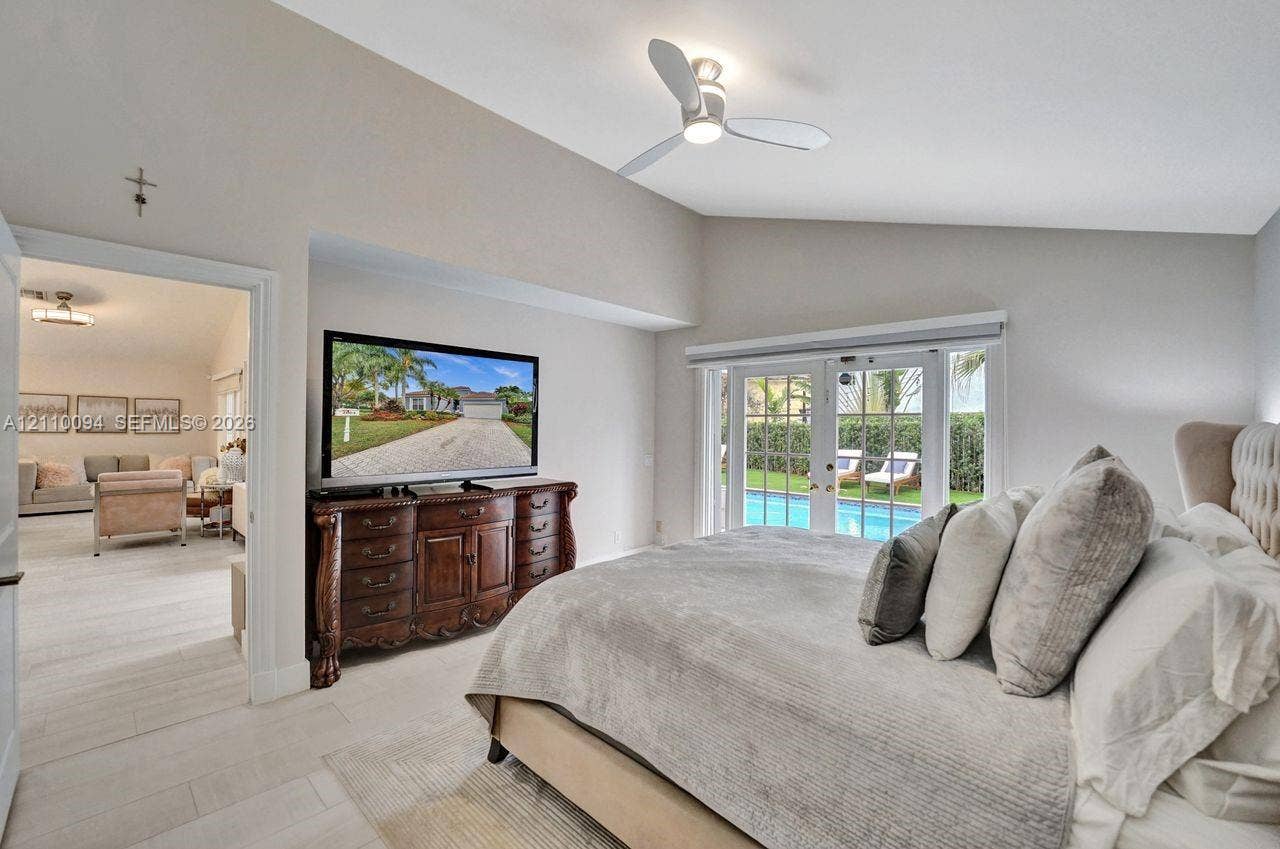2064 Island Circle, Weston, FL 33326 Vaulted ceilings, neutral paint, light-toned flooring, integrated ceiling fan with light fixture, and French doors featuring exterior pool access