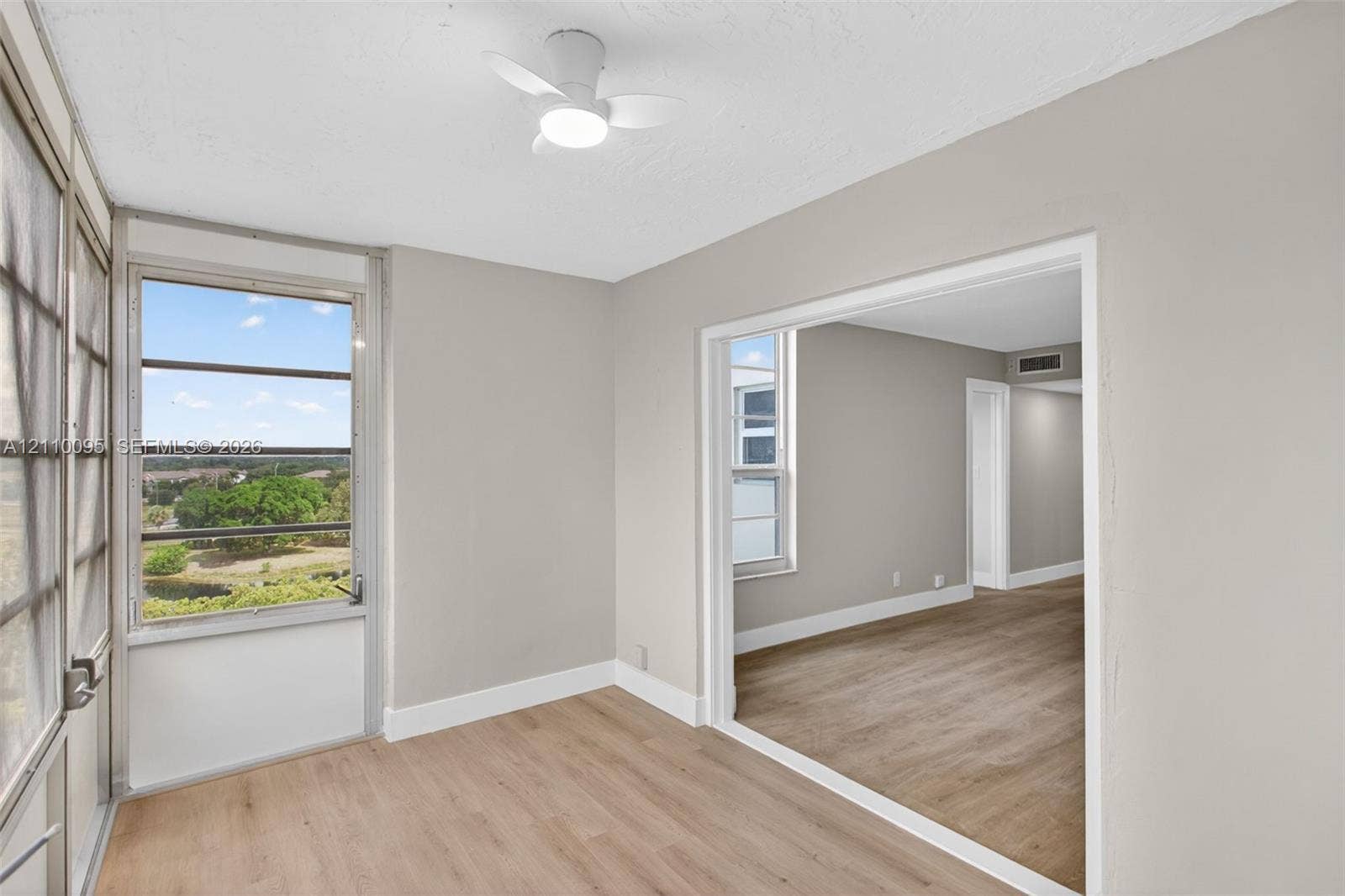 3090 N Course Drive, #807, Pompano Beach, Pompano Beach, FL 33069 Enclosed porch featuring wood-finish flooring, large window panels, and a ceiling-mounted light fixture with fan