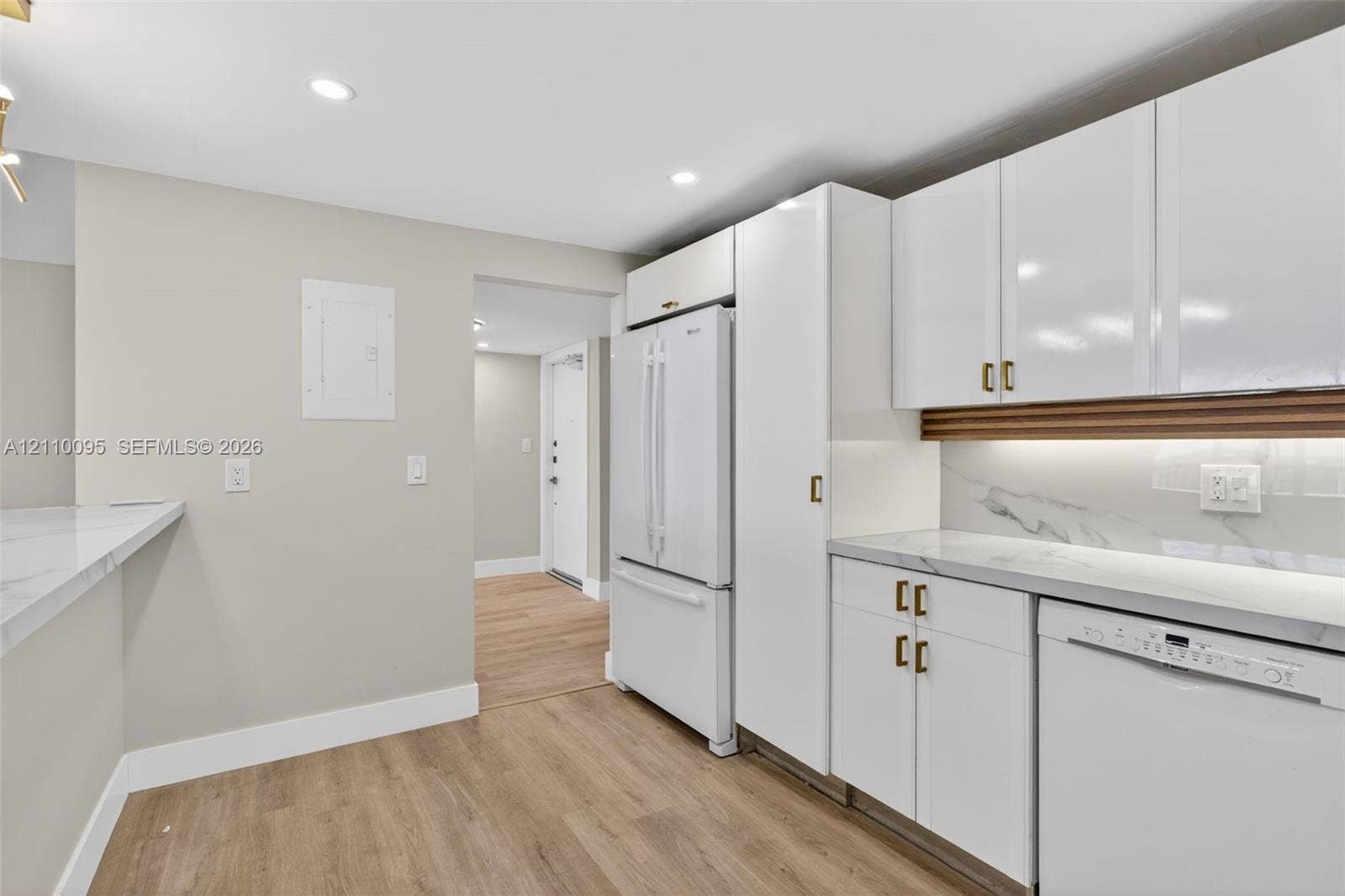 3090 N Course Drive, #807, Pompano Beach, Pompano Beach, FL 33069 Kitchen featuring white cabinetry with gold-tone hardware, stone-finish countertops, under-cabinet lighting, recessed ceiling lighting, and wood-finish flooring