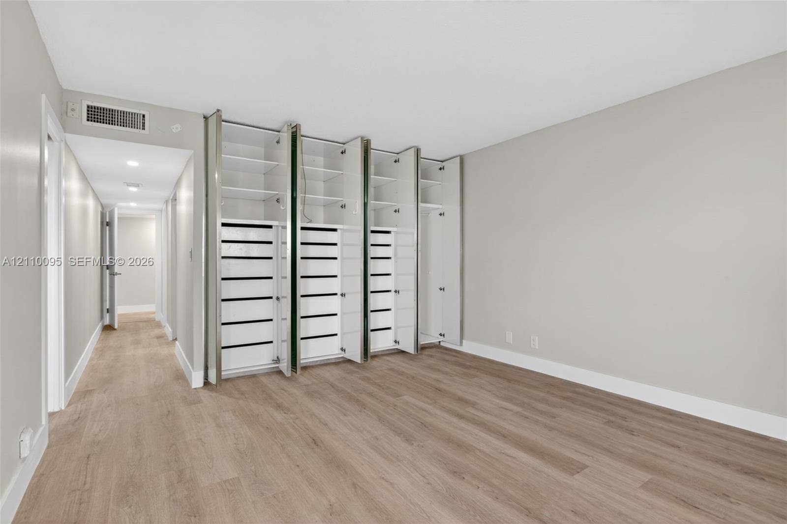 3090 N Course Drive, #807, Pompano Beach, Pompano Beach, FL 33069 Room featuring wood-finish flooring, recessed ceiling lighting, and floor-to-ceiling built-in cabinetry with integrated shelving and drawer storage