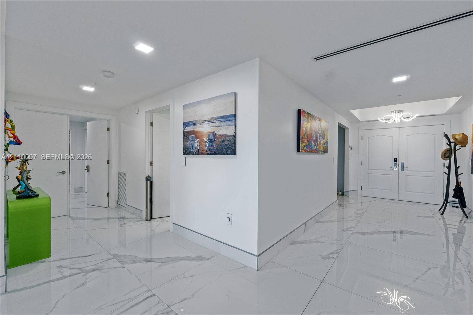 Foyer featuring large-format veined tile flooring, recessed ceiling lighting, a tray ceiling detail, and double-entry doors