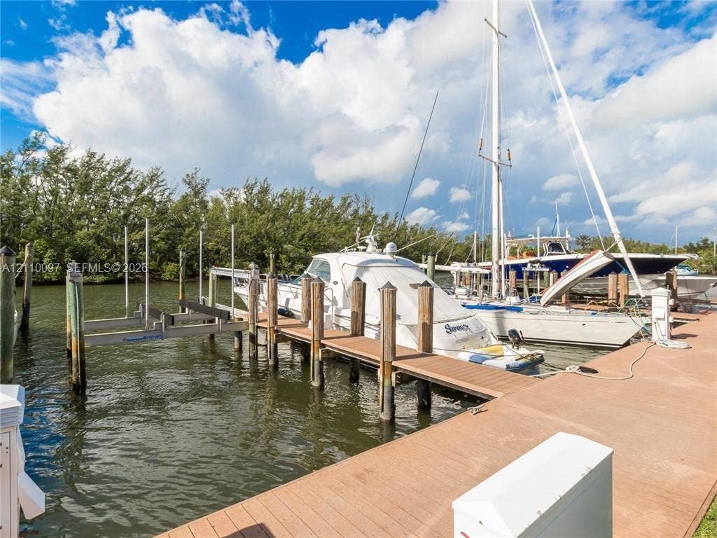 Waterfront wood-plank dock featuring a motorized boat lift and deep-water slip access