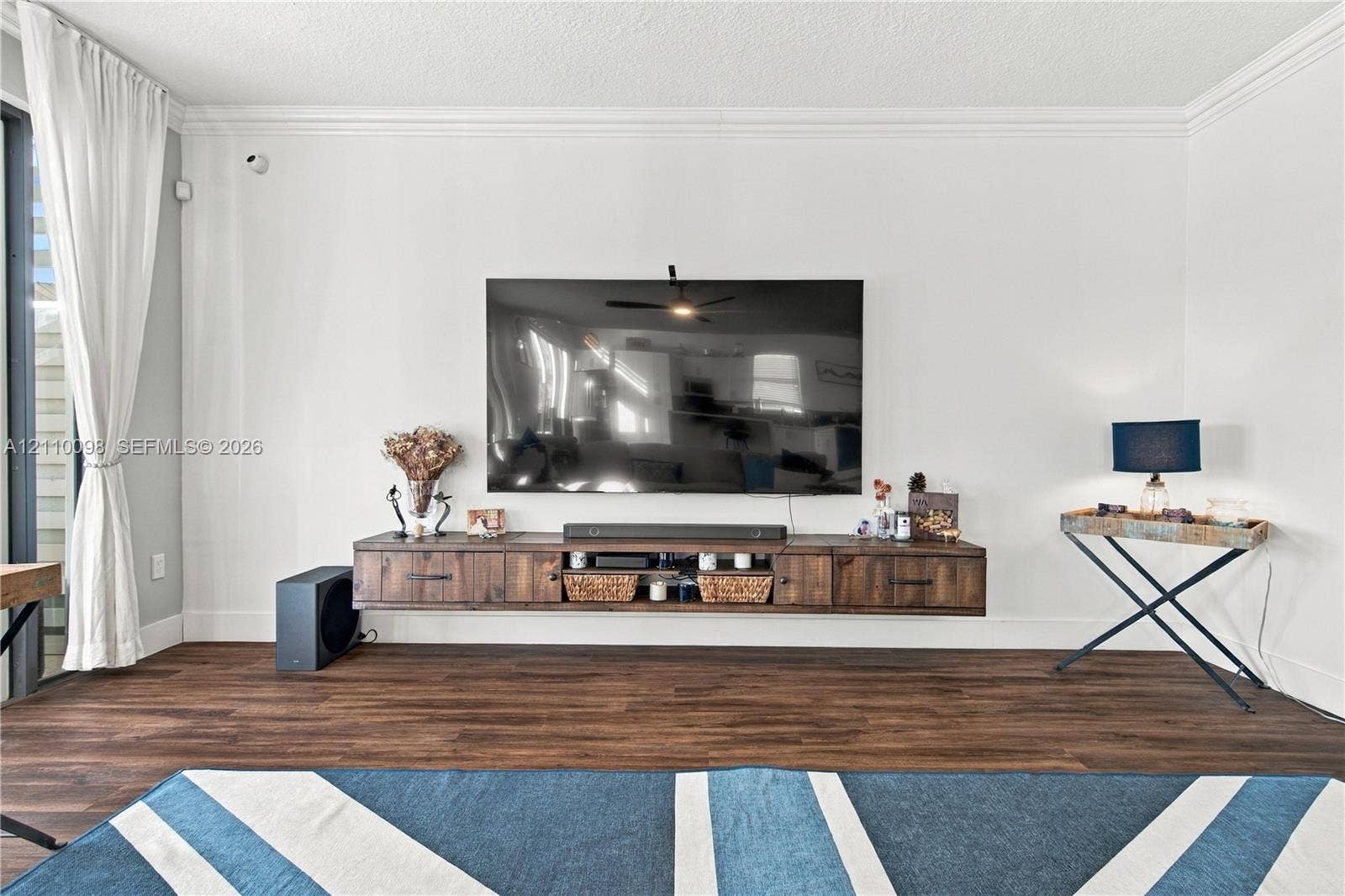 Wall-mounted wood-finish media console, crown molding, and wood-finish flooring