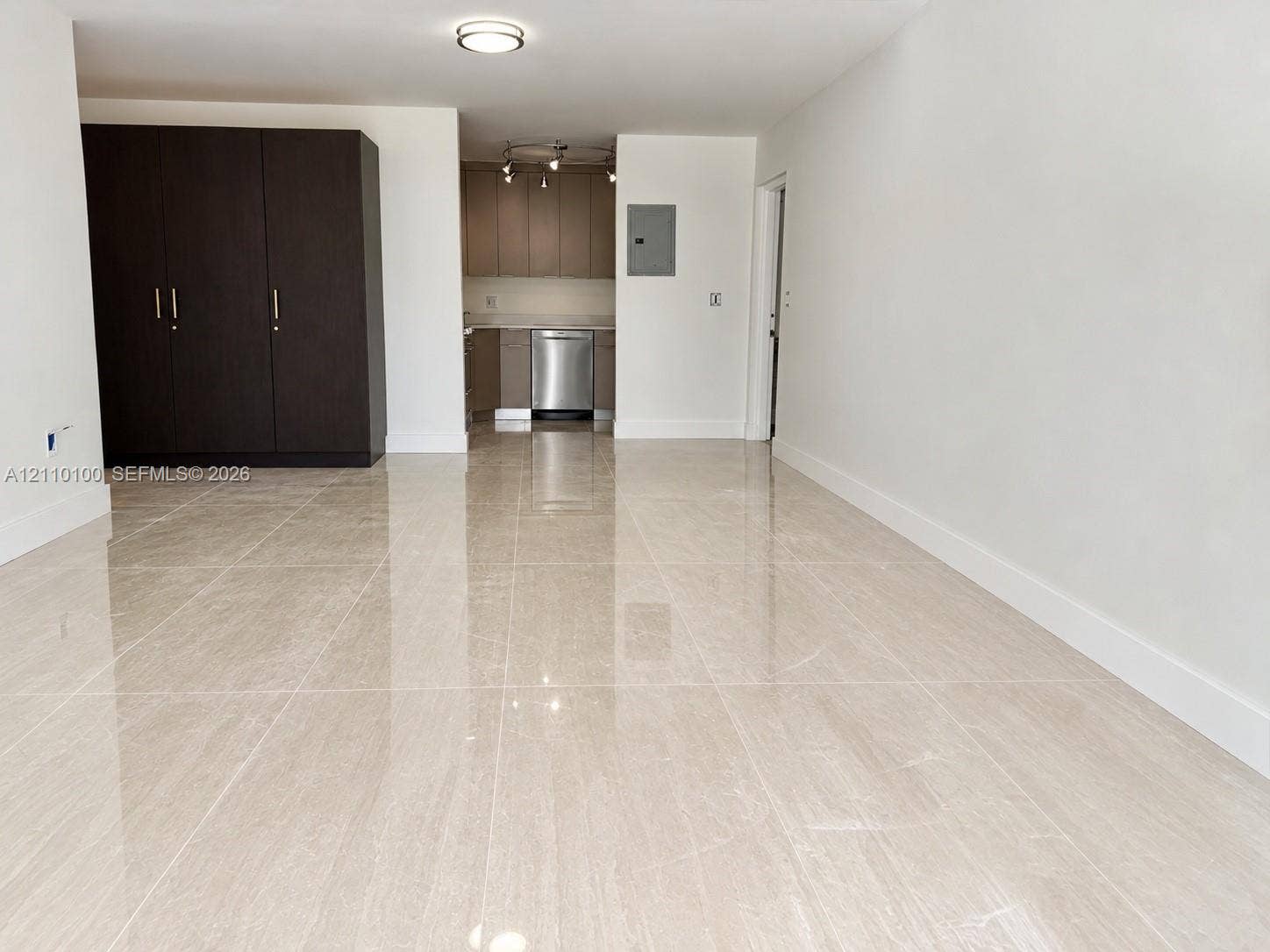 Large-format polished tile flooring, dark-toned built-in cabinetry, and neutral wall finishes