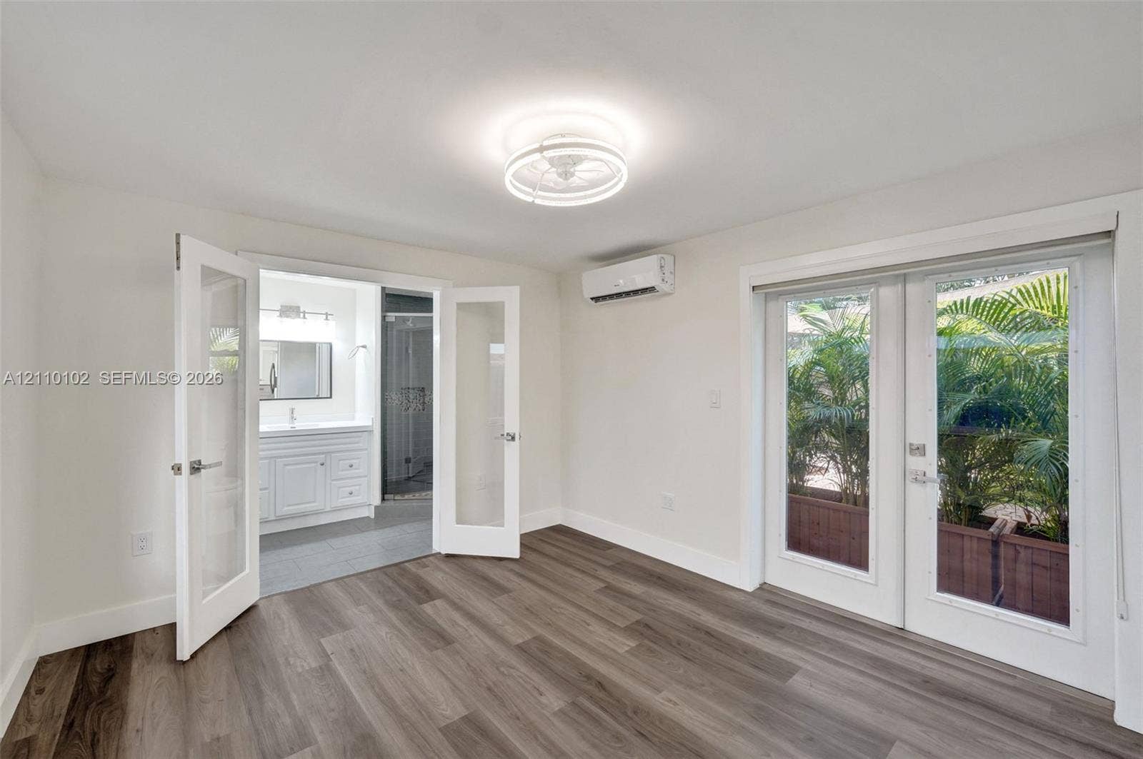 1224 NE 13th Avenue, #2, Fort Lauderdale, Fort Lauderdale, FL 33304 Wood-finish flooring, white double French doors, wall-mounted climate control unit, circular flush-mount ceiling light fixture, and glass-paneled exterior door