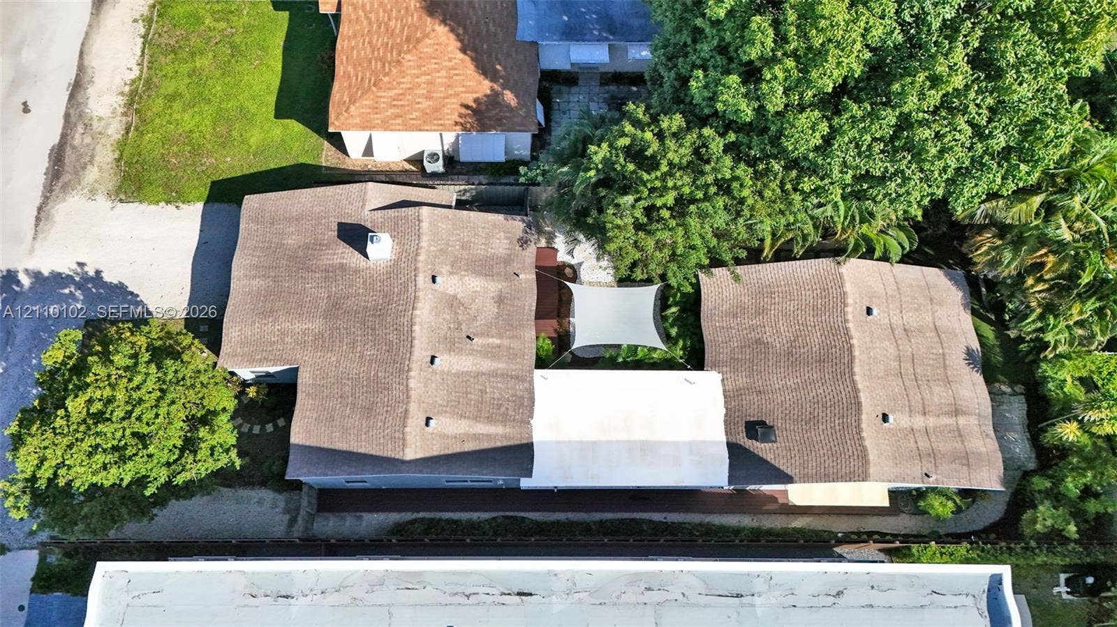 1224 NE 13th Avenue, #2, Fort Lauderdale, Fort Lauderdale, FL 33304 Aerial perspective of a multi-section roofline featuring asphalt shingles, a central paved courtyard, and mature perimeter trees