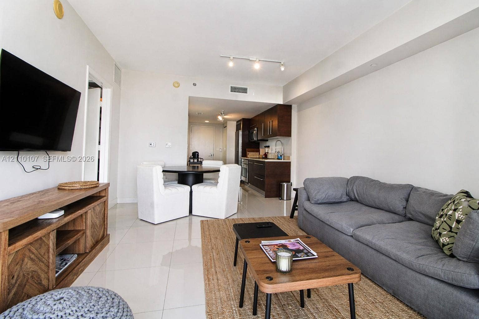 465 Brickell Avenue, #4604, Miami, Miami, FL 33131 Open concept area featuring large-format tile flooring, recessed track lighting, and a kitchen equipped with dark wood-finish cabinetry and stainless steel appliances