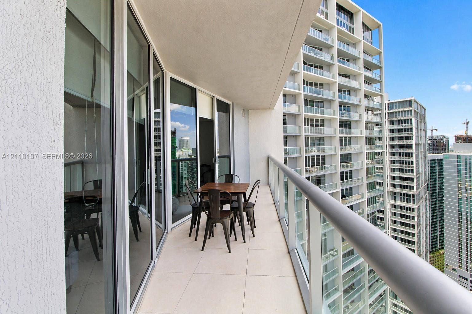 465 Brickell Avenue, #4604, Miami, Miami, FL 33131 Covered balcony featuring expansive glass sliding door entry, floor-to-ceiling windows, and a glass-paneled railing