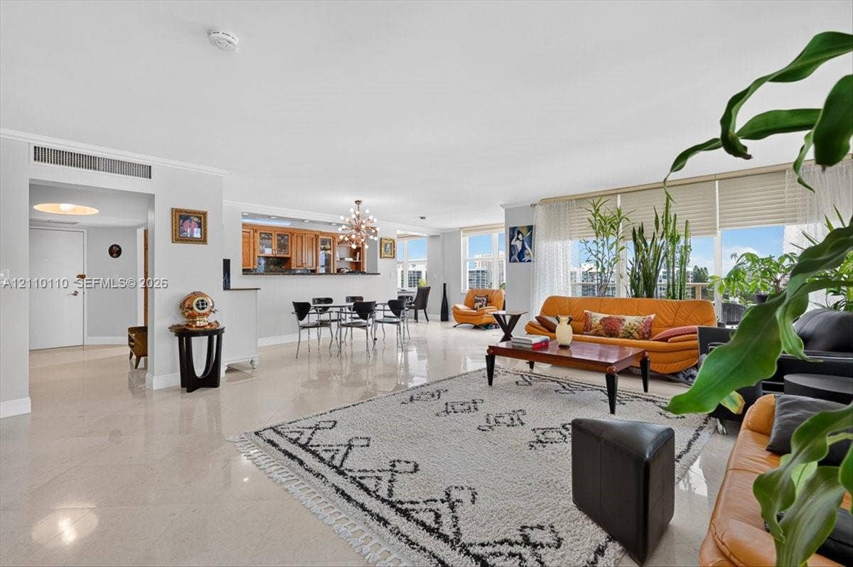 2751 S Ocean Drive, #801N, Hollywood, FL 33019 Open-concept interior featuring light-toned tile flooring, floor-to-ceiling windows, and a pass-through kitchen with built-in cabinetry and an attached breakfast bar