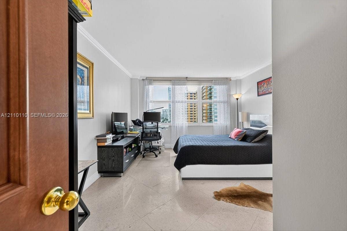 2751 S Ocean Drive, #801N, Hollywood, FL 33019 Room featuring large-format diagonal tile flooring, crown molding, and expansive multi-panel windows