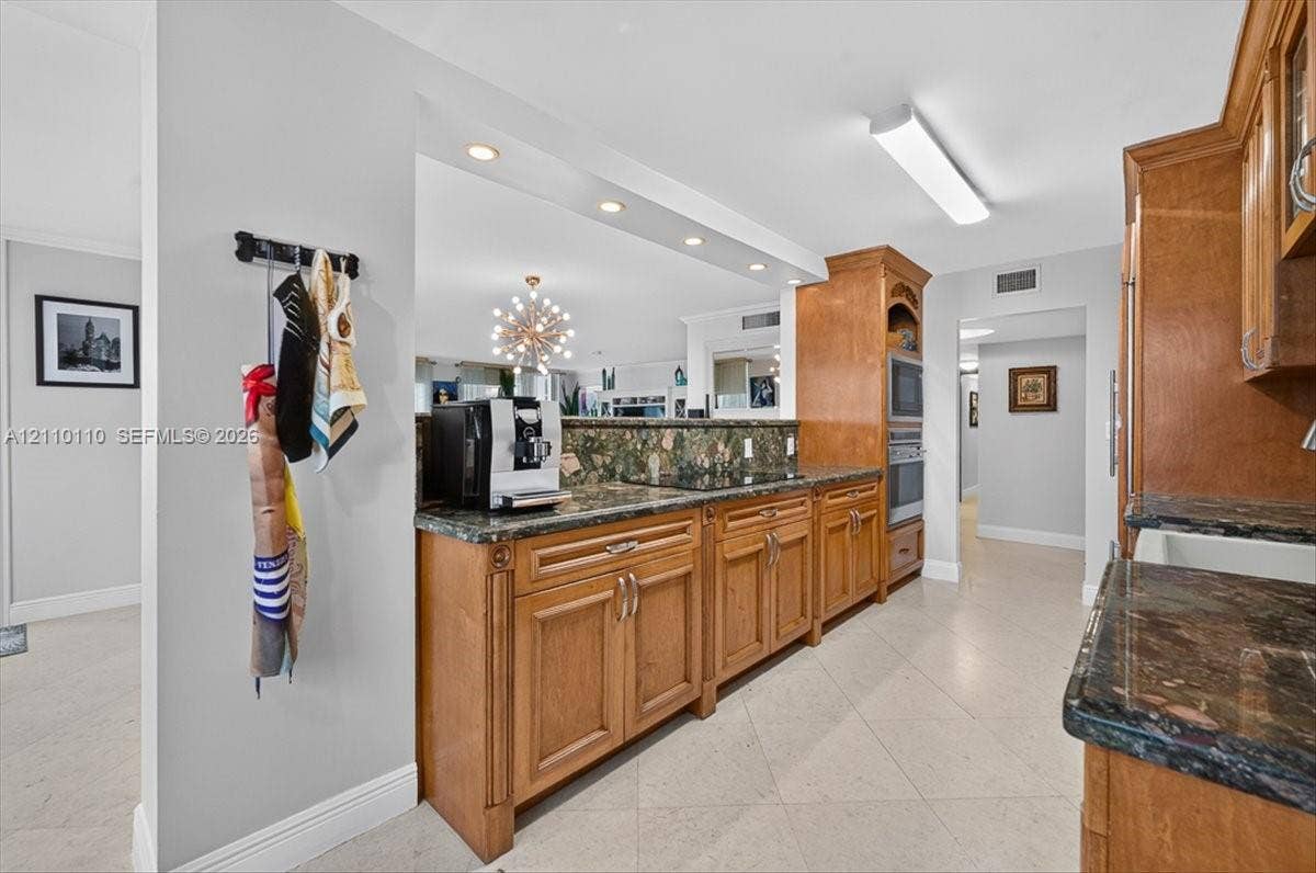2751 S Ocean Drive, #801N, Hollywood, FL 33019 Kitchen featuring medium-tone wood cabinetry, stone countertops, integrated wall ovens, recessed lighting, and tile flooring