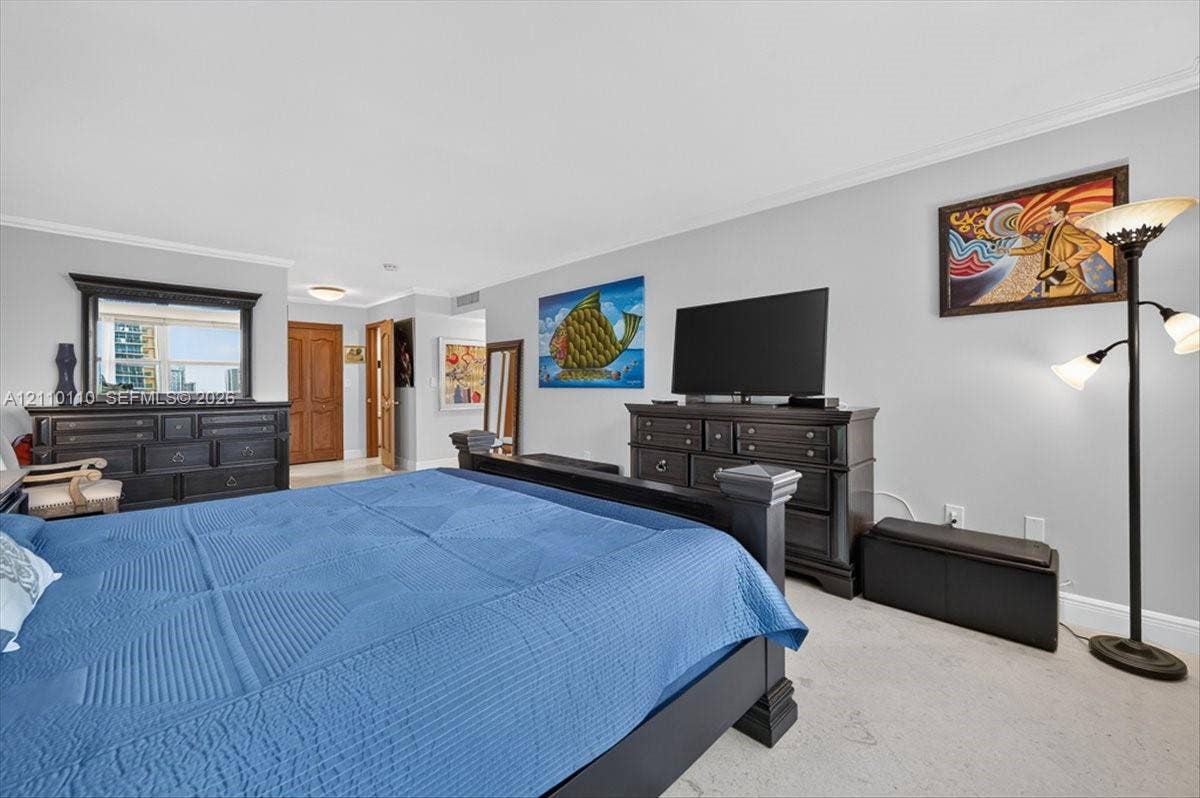 2751 S Ocean Drive, #801N, Hollywood, FL 33019 Neutral-toned walls, crown molding, light-colored carpeting, and natural light via the window