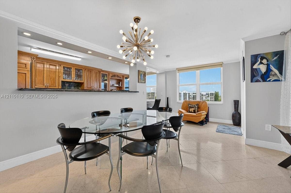 2751 S Ocean Drive, #801N, Hollywood, FL 33019 Open-concept dining area featuring stone flooring, a multi-light starburst chandelier, and recessed lighting