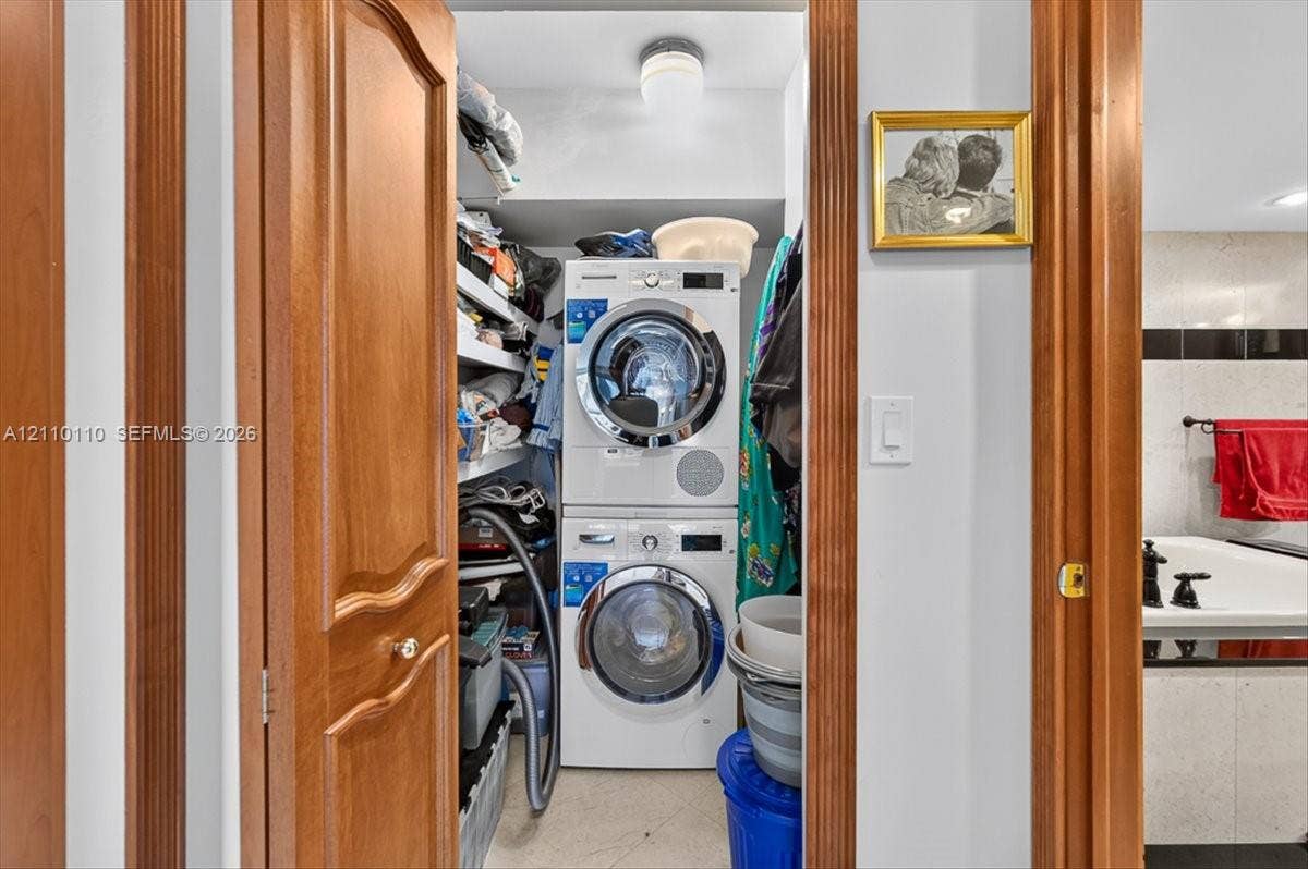 2751 S Ocean Drive, #801N, Hollywood, FL 33019 Laundry closet featuring a stackable washer and dryer unit, built-in shelving, and a dome-style ceiling light fixture