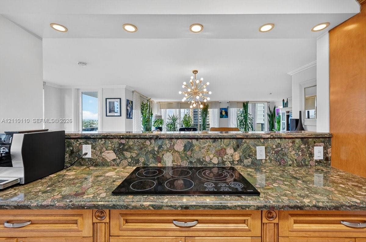 2751 S Ocean Drive, #801N, Hollywood, FL 33019 Kitchen featuring multi-tonal stone countertops, backsplash, inset electric cooktop, recessed ceiling lighting, and wood-finish cabinetry