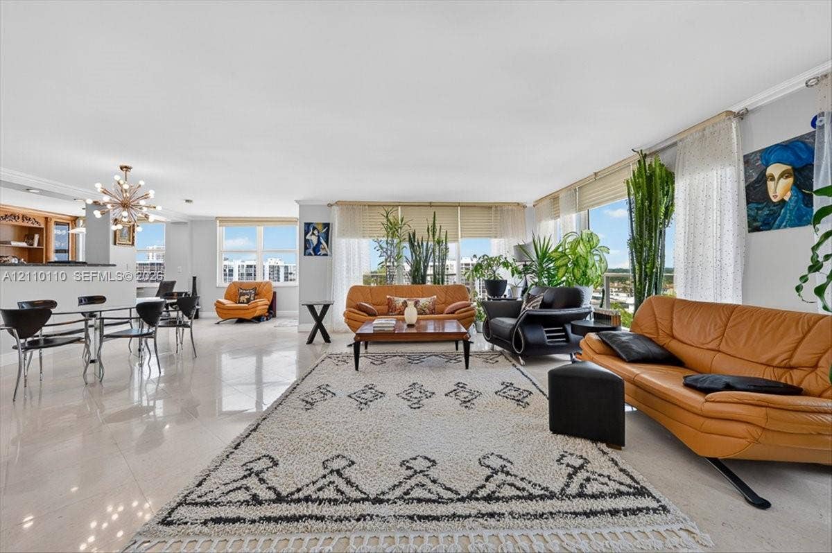 2751 S Ocean Drive, #801N, Hollywood, FL 33019 Open-concept interior featuring large-format tile flooring, floor-to-ceiling windows, built-in cabinetry, and a modern sputnik-style chandelier