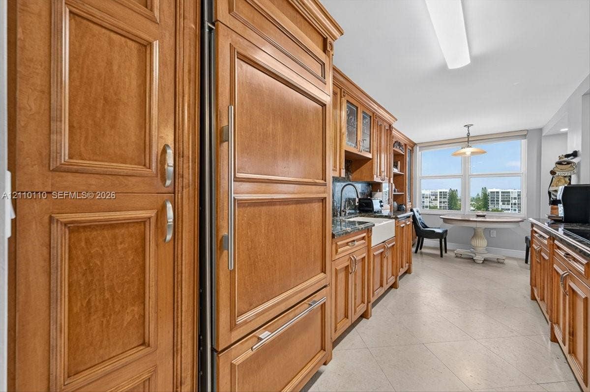 2751 S Ocean Drive, #801N, Hollywood, FL 33019 Custom cabinetry with integrated paneled refrigerator, farmhouse sink, dark stone countertops, and tile flooring