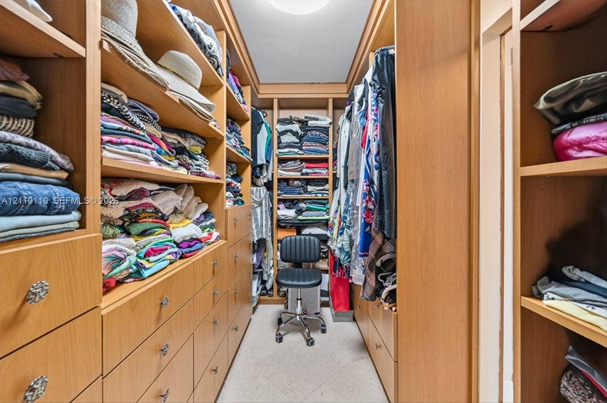 2751 S Ocean Drive, #801N, Hollywood, FL 33019 Walk-in closet featuring extensive custom wood-finish built-in cabinetry, floor-to-ceiling shelving, multiple integrated storage drawers, and recessed ceiling lighting