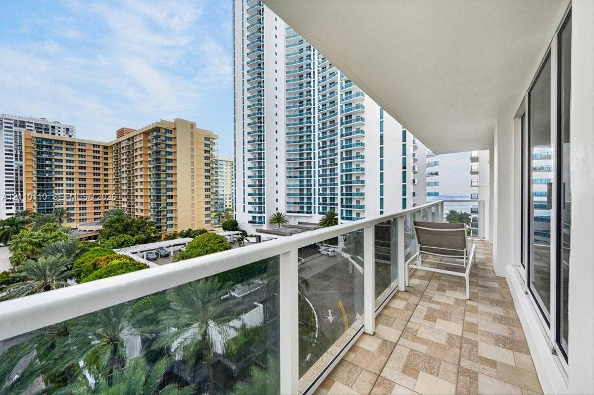 2751 S Ocean Drive, #801N, Hollywood, FL 33019 Covered balcony featuring tiled flooring, glass-panel railing, and floor-to-ceiling glass sliding doors