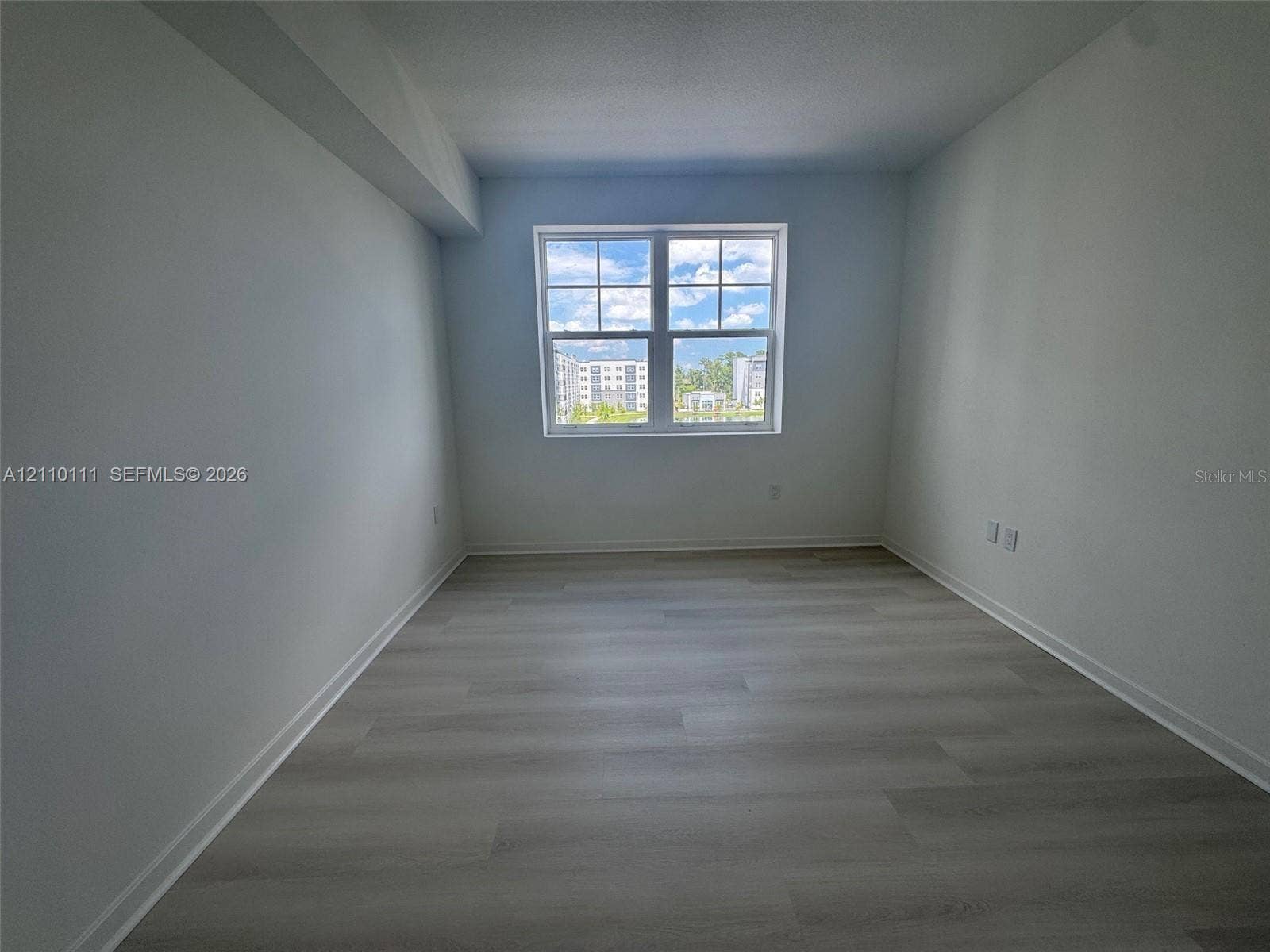 5563 Millenia Park Boulevard, #315, Orlando, Orlando, FL 32839 Neutral-toned interior space featuring wood-finish flooring and a multi-pane window
