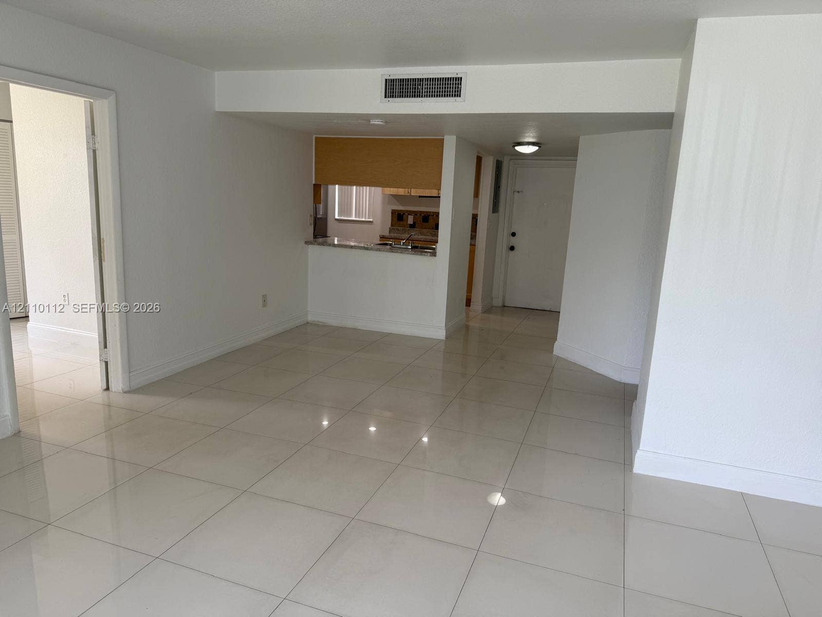 14185 SW 87th Street, #A110, Miami, FL 33183 Polished tile flooring, kitchen pass-through window, and neutral wall finishes