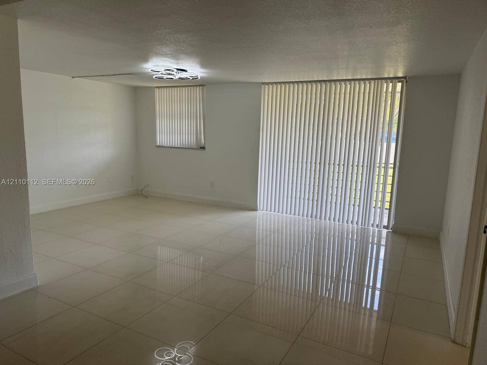 14185 SW 87th Street, #A110, Miami, FL 33183 Large-format tile flooring, recessed flush-mount geometric ceiling lighting, and vertical window blinds