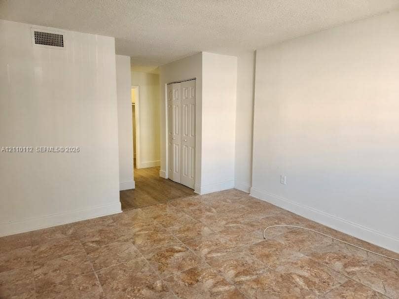 14185 SW 87th Street, #A110, Miami, FL 33183 Interior space featuring neutral wall tones, large-format tile flooring, wood-finish flooring, and a built-in bifold closet