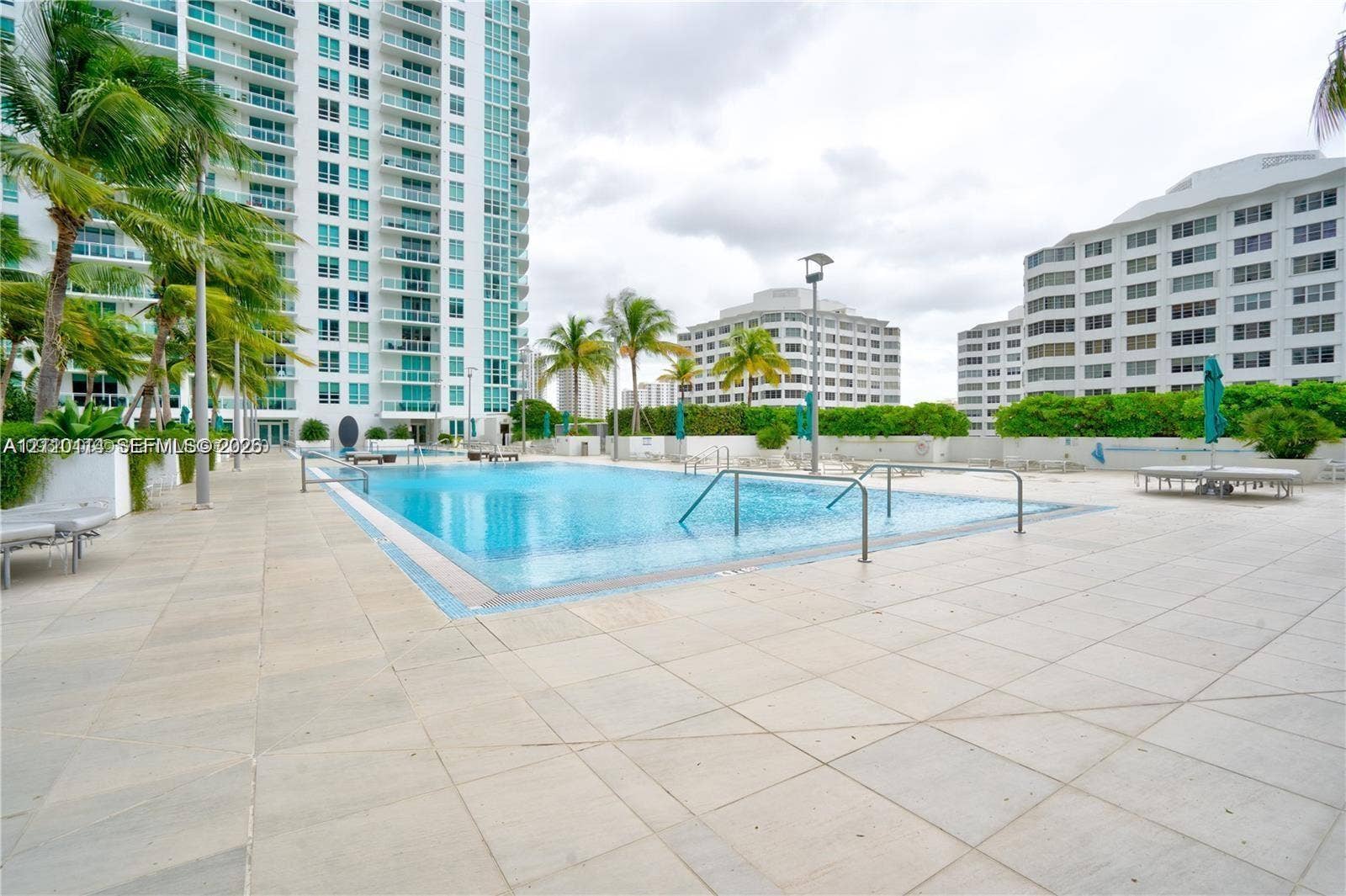 950 Brickell Bay Drive, #5108, Miami, Miami, FL 33131 In-ground swimming pool featuring tile coping, metal handrails, and a paved deck surface