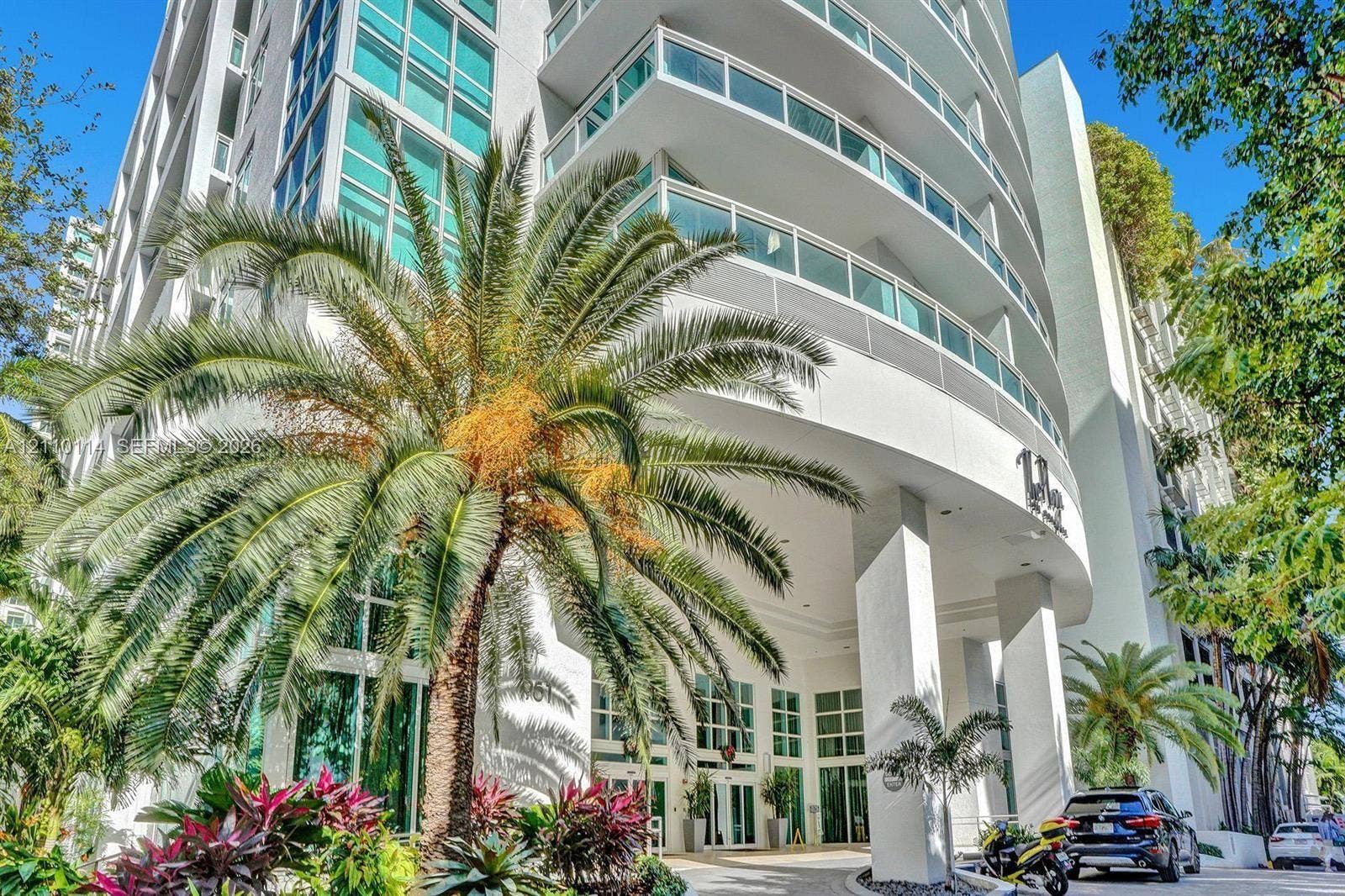 950 Brickell Bay Drive, #5108, Miami, Miami, FL 33131 Modern high-rise exterior featuring curved balconies, floor-to-ceiling glass windows, concrete structure, and ground-level landscaping