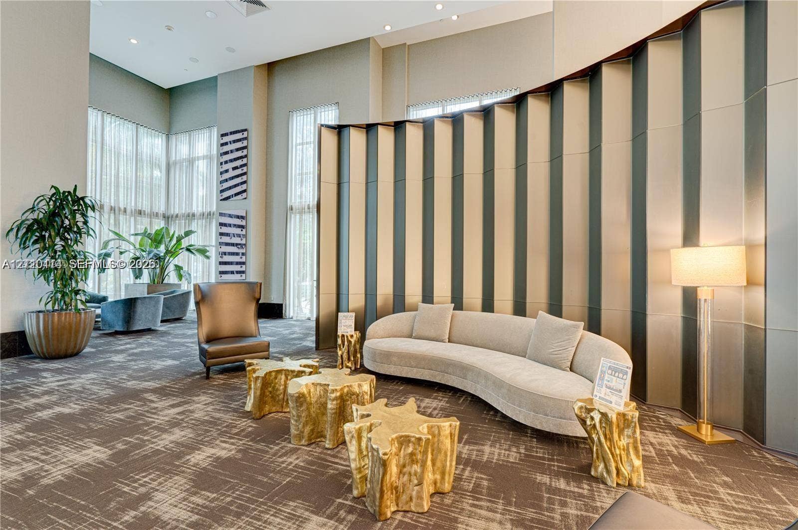 950 Brickell Bay Drive, #5108, Miami, Miami, FL 33131 Double-height ceilings featuring floor-to-ceiling windows, recessed lighting, and a prominent curved feature wall with vertical metallic paneling