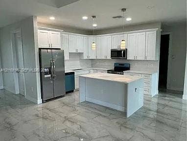 3304 11 Street W, #0, Lehigh Acres, FL 33971 Kitchen featuring white cabinetry, center island with stone-finish countertop, stainless steel refrigerator, built-in microwave, and large-format tile flooring