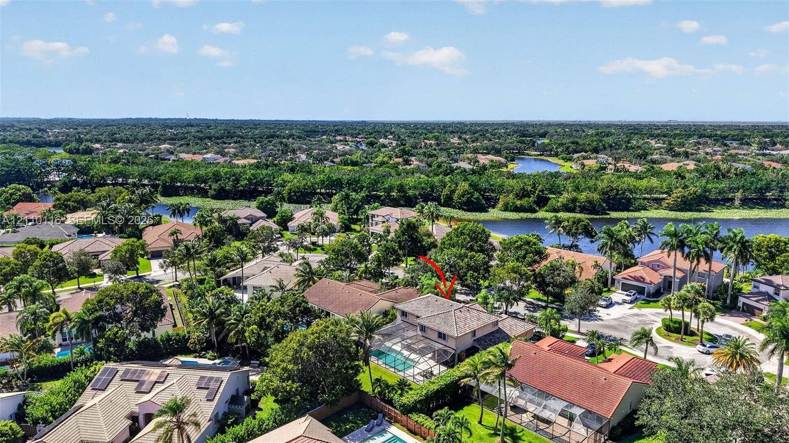 Two-story residence featuring a tile roof, an enclosed swimming pool, and a private rear yard with mature landscaping