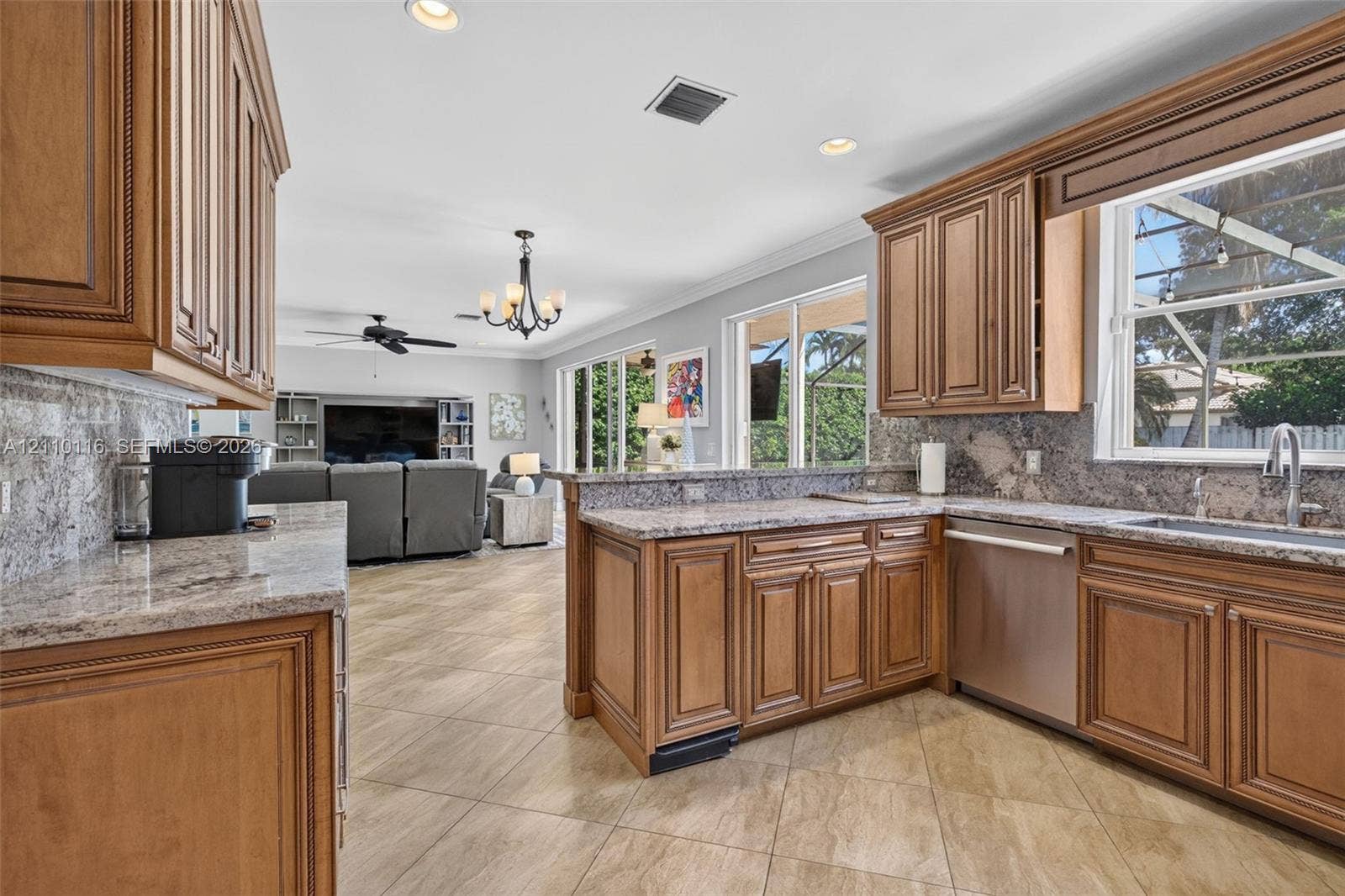 Kitchen featuring raised-panel wood cabinetry, stone countertops, stainless steel dishwasher, tile flooring, and recessed lighting
