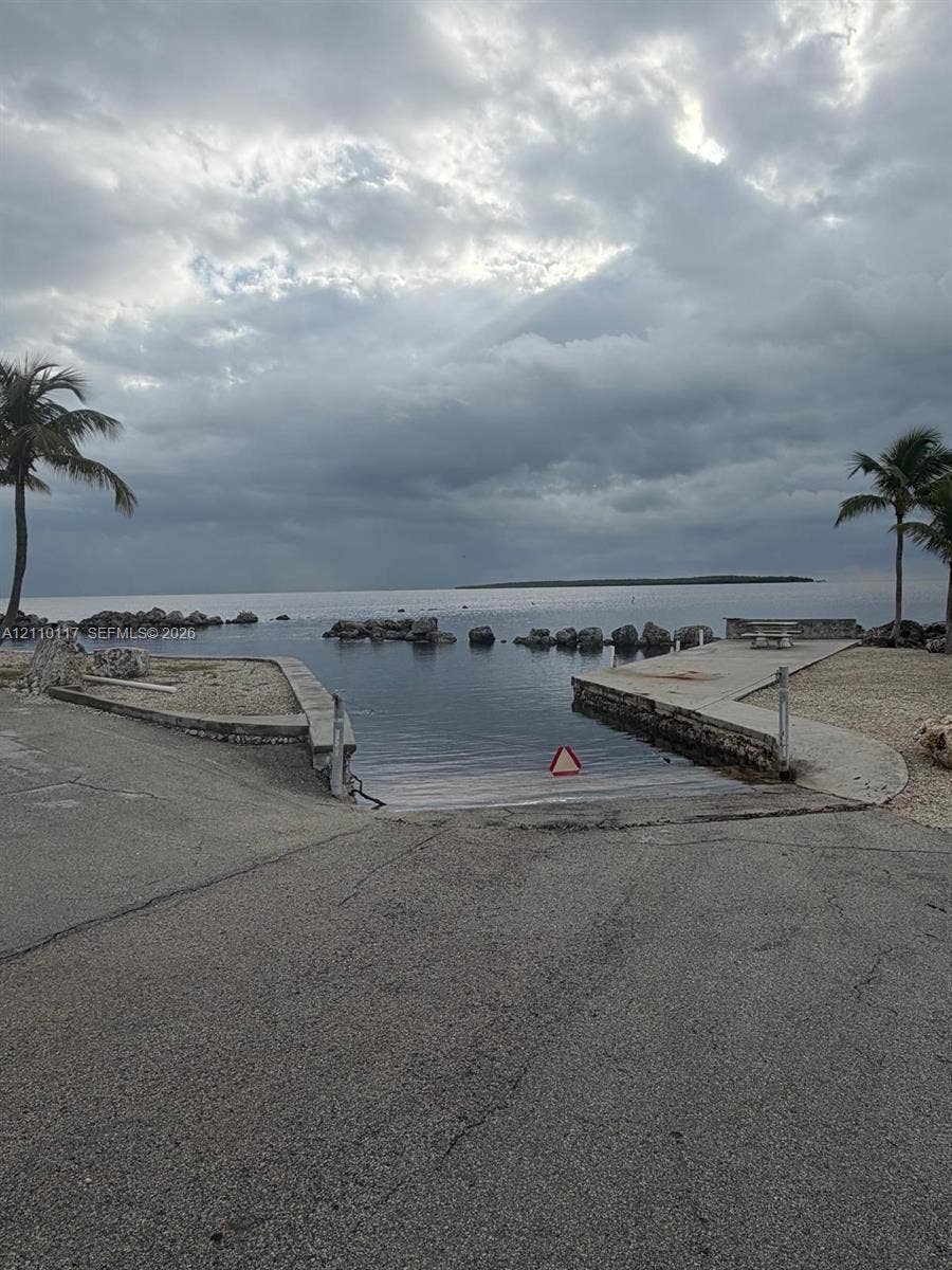 Private boat ramp featuring a concrete slipway, stone shoreline stabilization, and integrated waterfront bulkhead