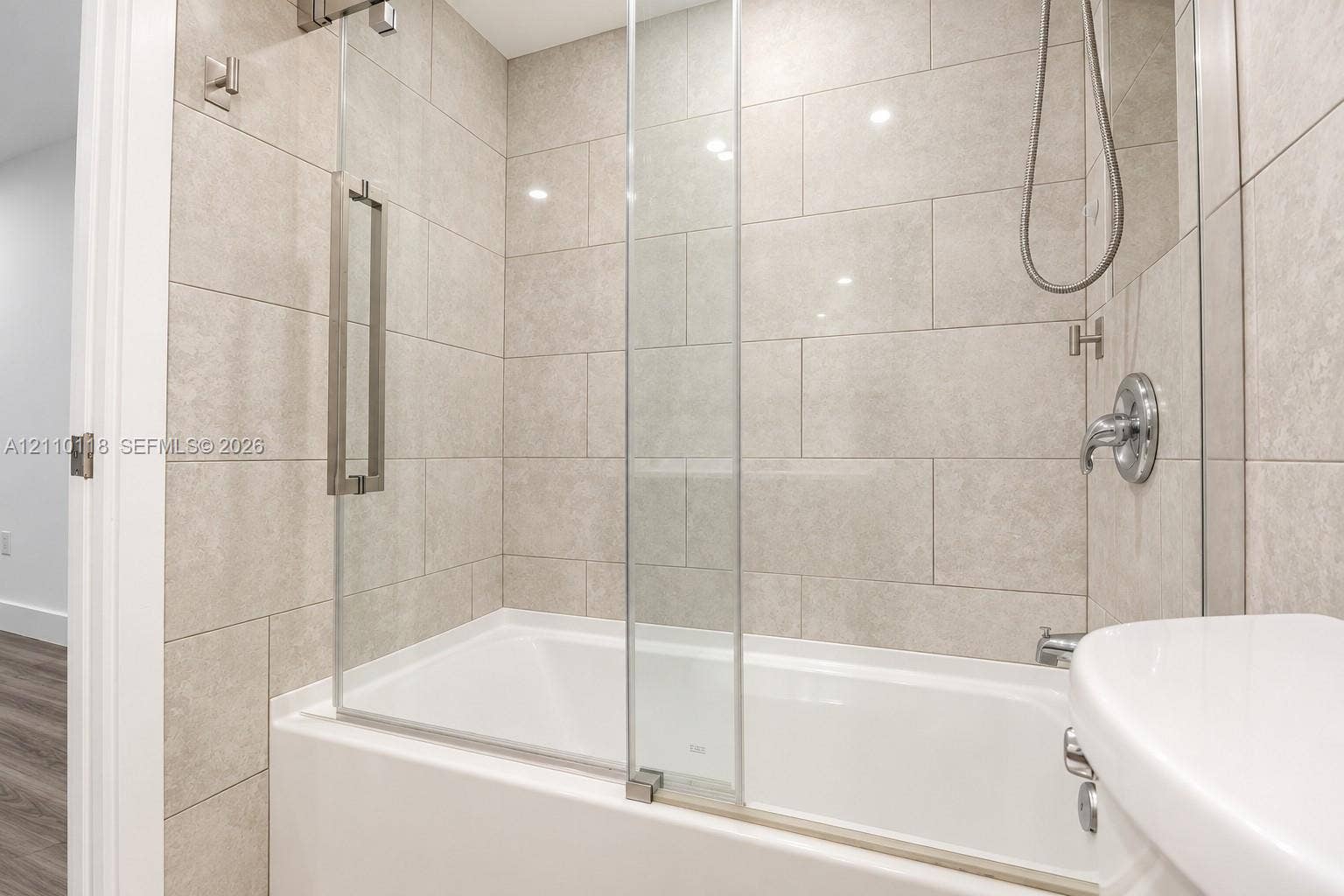 7991 SW 152nd Avenue, #701-7, Miami, Miami, FL 33193 Full-height neutral wall tiling, integrated glass shower screen, chrome plumbing fixtures, and a white soaking tub