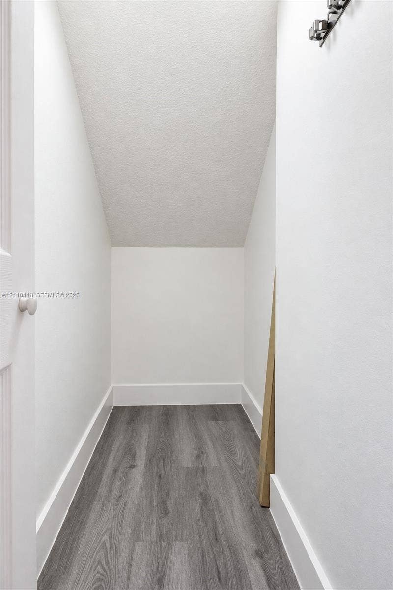 7991 SW 152nd Avenue, #701-7, Miami, Miami, FL 33193 Storage area featuring wood-finish flooring, white walls, and a multi-bulb ceiling fixture