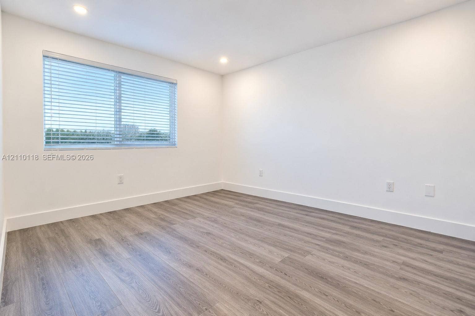 7991 SW 152nd Avenue, #701-7, Miami, Miami, FL 33193 Neutral-toned room featuring wood-finish flooring, recessed lighting, and a single window with horizontal blinds