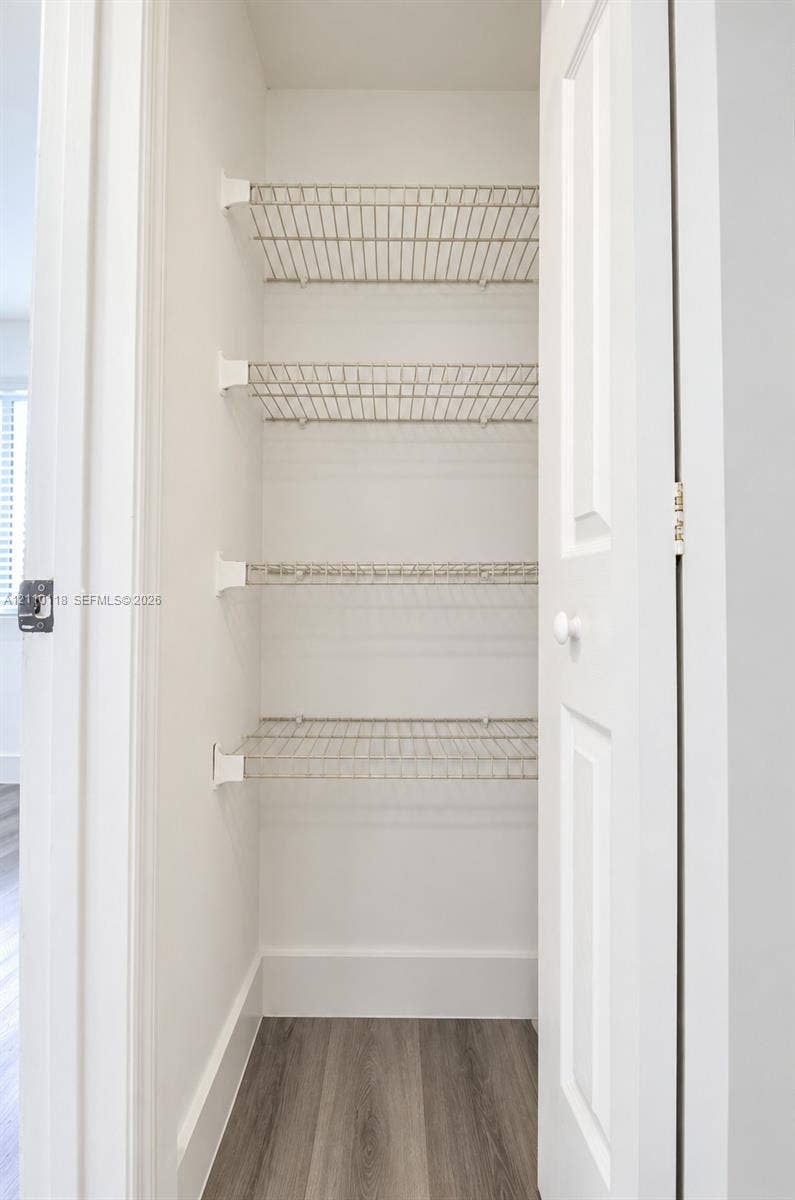 7991 SW 152nd Avenue, #701-7, Miami, Miami, FL 33193 Storage closet featuring white-painted walls, four tiers of wire shelving, and wood-finish flooring