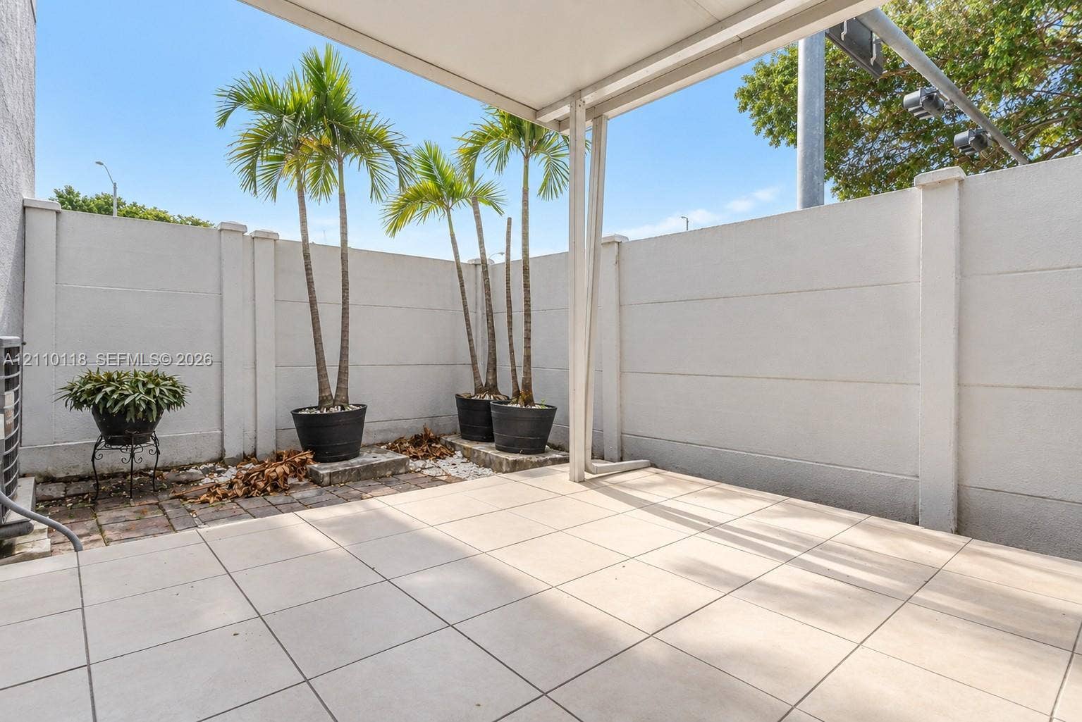 7991 SW 152nd Avenue, #701-7, Miami, Miami, FL 33193 Covered patio featuring large-format tile flooring and a privacy wall enclosure