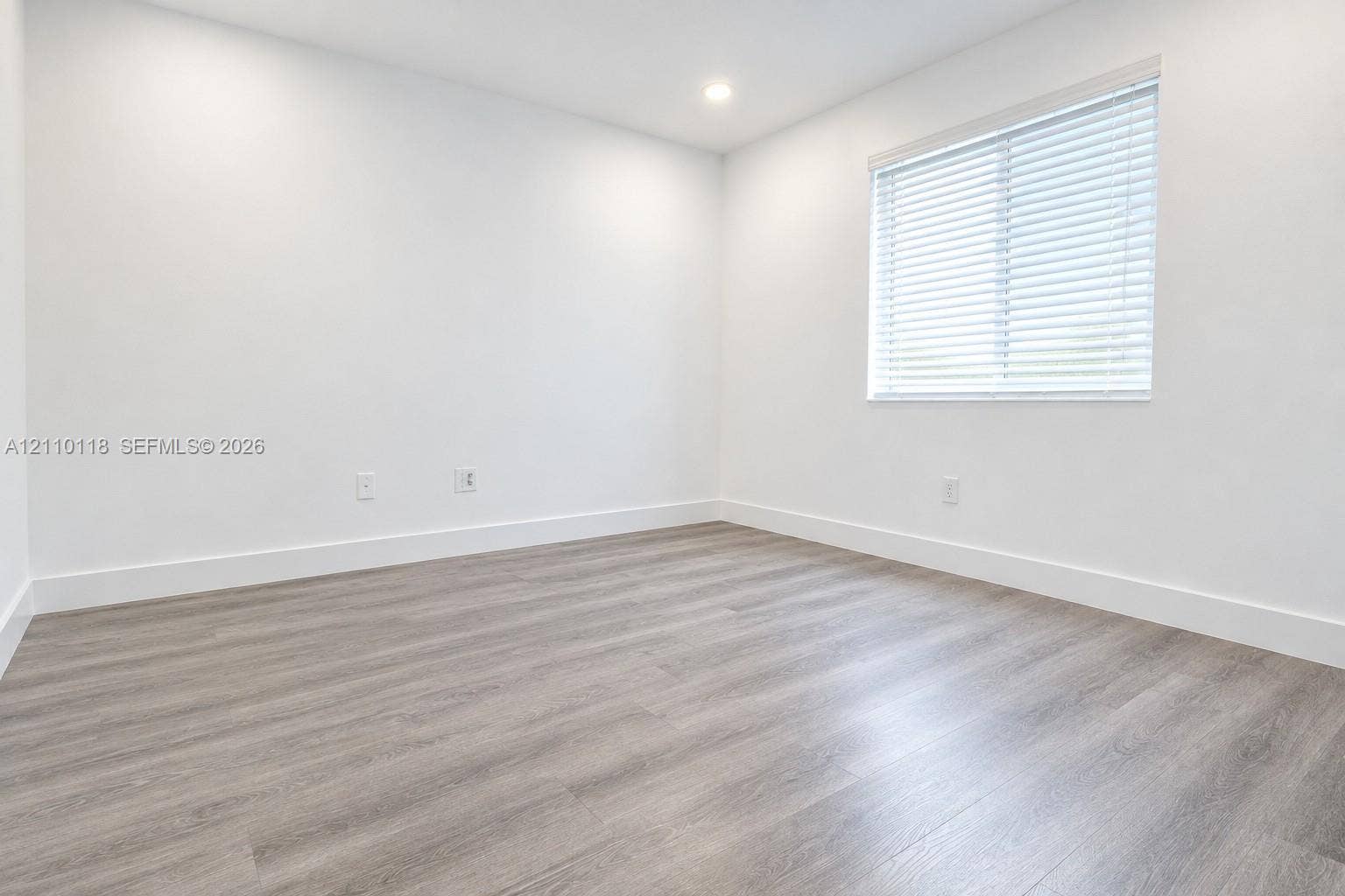7991 SW 152nd Avenue, #701-7, Miami, Miami, FL 33193 Neutral interior space featuring wood-finish flooring, crisp white walls, recessed ceiling lighting, and a window with horizontal blinds