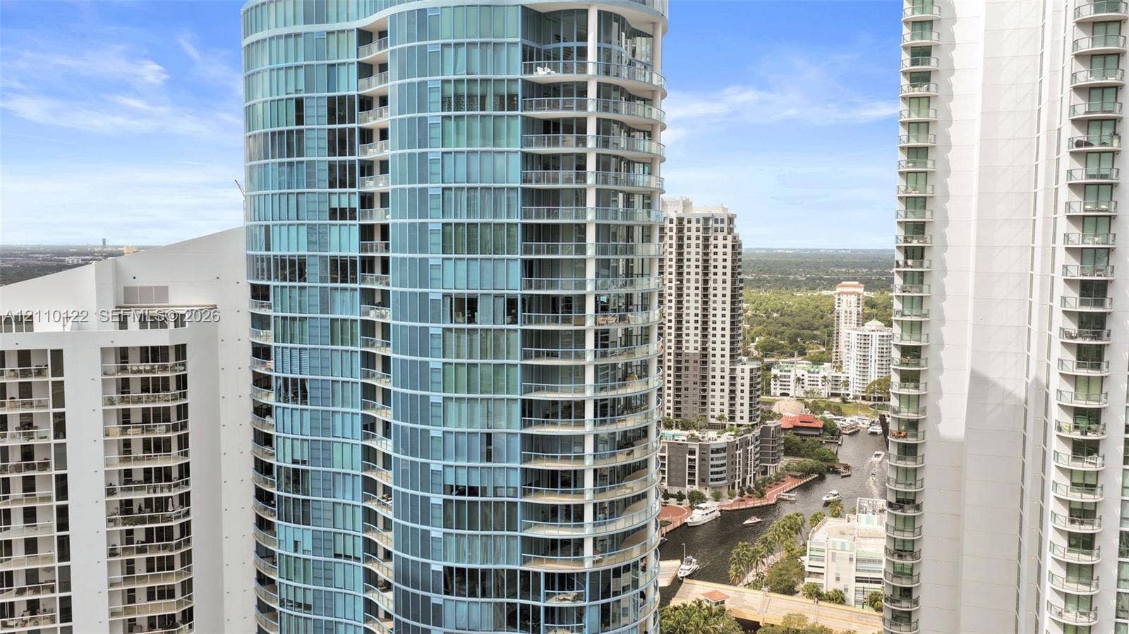 333 Las Olas Way, #2708, Fort Lauderdale, FL 33301 High-rise building featuring a glass facade, curved structural design, and multiple private balconies