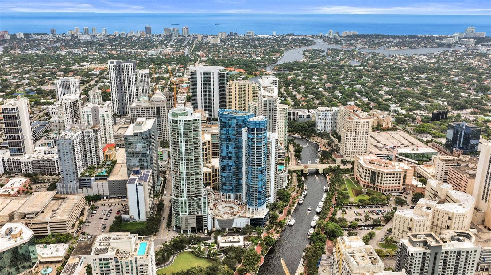 333 Las Olas Way, #2708, Fort Lauderdale, FL 33301 Aerial perspective of urban high-rise development featuring glass-facade towers, proximity to waterway, surrounding metropolitan infrastructure, and coastal horizon
