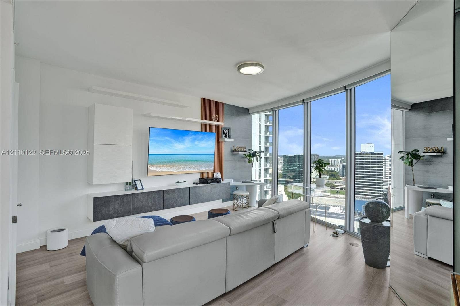 333 Las Olas Way, #2708, Fort Lauderdale, FL 33301 Floor-to-ceiling windows, wood-finish flooring, built-in wall cabinetry, and accent wall paneling