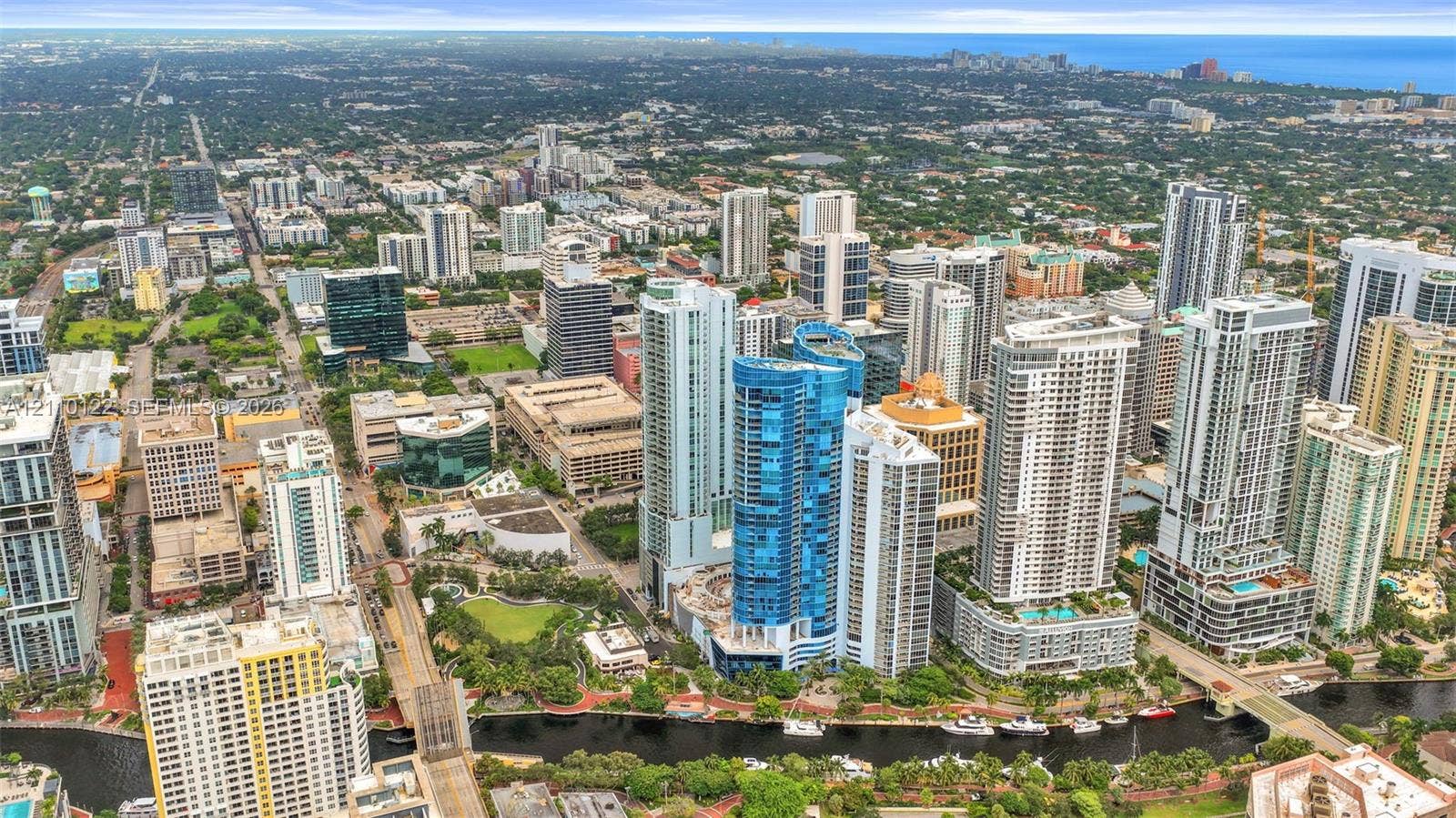 333 Las Olas Way, #2708, Fort Lauderdale, FL 33301 Aerial perspective of a high-density urban environment featuring skyscraper architecture, proximity to a waterway, integrated green spaces, and dense metropolitan infrastructure
